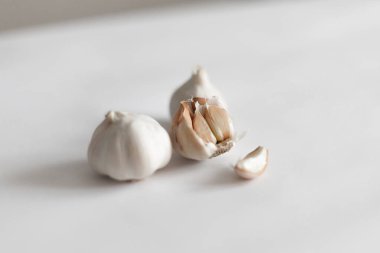 Tam sarımsak ve sarımsak da beyaz arkaplanda tuz ve biber karışımı ile birlikte bulunur.