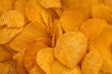 Cipslerin fotoğrafı makro fotografı kapat. Fotoğrafın tamamı cipslerle dolu. Parlak cips tadı.