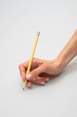 Hafif arka plan yakın çekim fotoğraf makrosu üzerine yazmaya hazır bir kalemi tutan el.