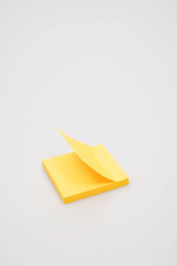 Köşesi soyulmuş, parlak sarı yapışkan notlar yığını. Yakın çekim fotoğraf makrosu görünümü.