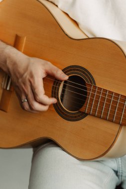 Akustik gitar çalan bir kişinin eli, akustik gitar tıngırdatan bir elin, akustik gitar çalan bir müzisyenin eli.