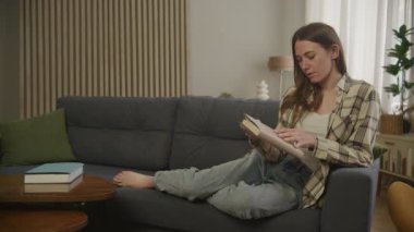 Evinde oturup kitap okuyan güzel Brunet Kadını Oturma odasında