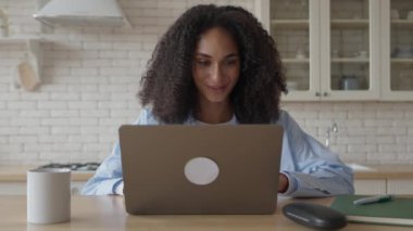 Serbest Kıvırcık Kadın Mutfakta Dizüstü bilgisayar Kullanıyor 
