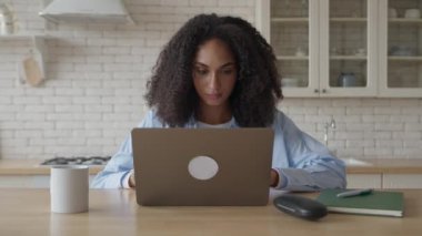 Evde Mutfakta Dizüstü bilgisayar kullanan Afrikalı Kıvırcık Kadın
