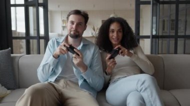 Video oyunları oynarken zaferlerini kutlayan neşeli genç çift, yüksek kalite 4K görüntü