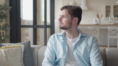 Telefona cevap veren adam oturma odasında konuşuyor, yüksek kalite 4K görüntü.