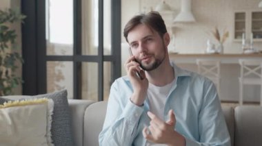 Yakışıklı Adam Koltukta Oturuyor ve Telefonla Konuşuyor, Yüksek Kaliteli 4K görüntü