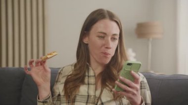 Akıllı Telefon 'da Mesaj Yazan ve Dairede Pizza Yiyen Kadın 