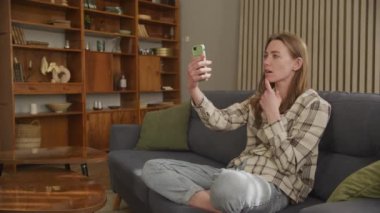 Üzgün Kadın Ev Kanepesinde Konuşuyor ve Kötü Haberler Aldı, Oturma Odasında Konuşan Depresyondaki Kadın, Oturma Odasında Mutsuz Kız Oturan Klibi Arıyor