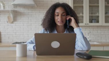 Telefon görüşmesi sırasında gülümseyen Afrikalı Amerikalı Kadın Laptop İş, yüksek kalite 4K görüntü