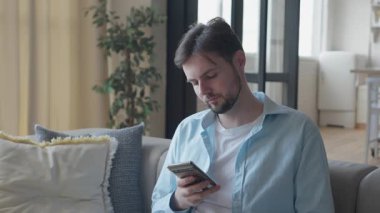 Genç Adam Kaydıran Akıllı Telefon Evde Rahat Vibe 4k Style, yüksek kalite 4K görüntü