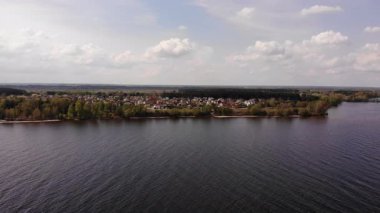 Adaları ile Güzel Göl Ağaçlar ve Evlerle çevrili, Gökyüzü Açık Güneş Parlıyor, Sakin Göl 'ün Görkemli Hava Manzarası Avrupa' daki Adaları, Cennet Gölü kıyısındaki Köy Evleri