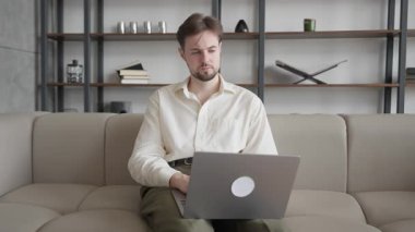 Ofisindeki telefona dizlerinde dizüstü bilgisayarla cevap veren adam. Meşgul Profesyonel, Dijital İletişim, Uzaktan Çalışma, İş Konuşması, Modern İşyeri, Şirket Yaşam Tarzı, Yüksek Kaliteli 4K Görüntü