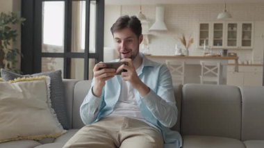 Heyecanlı Adam Mobil Oyunu Kazandı, Akıllı Telefon 'da oynarken Yumrukla Şerefe. Heyecanlı Oyuncu Zaferi Kutluyor, Saf Neşe ve Zaferi İfade Ediyor. Çevrimiçi Oyun Yarışması, Eğlence