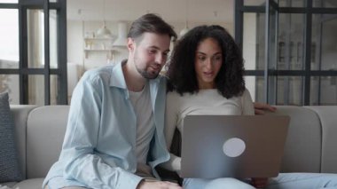 Çift laptopta şaşırtıcı bir şey konuşuyor odaklanmış ve nişanlı görünüyor. Meraklı Adam ve Kadın Beklenmedik Haberlere Tepki Veriyor, Ekrana Yoğunlaşıyor. Nişanlı tartışması. Yüksek kalite 4k görüntü