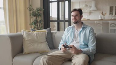 Oturan Genç Adam Apartmanda Video Oyunları oynuyor. Yüksek kalite 4k görüntü