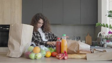 Modern mutfaktan alışveriş yaptıktan sonra taze ürünleri sınıflandıran kadın. Doğal Işık, Temiz İç, Sağlıklı Yaşam Tarzı, Bakkal Örgütü, Ev Hayatı, Bilinçli Yaşam, Mevsimsel İçindekiler