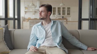 Evdeki koltukta uzanan, uzaktan kumandalı ve odaklanmış bir adam. Boş Zaman İçerde, Rahat Oturma Odası, Günlük Yaşam Tarzı, Sevdiği Şovları İzleme, Haftasonu Gevşeme Konsepti