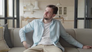 Ev telefonuna cevap veren, evde sohbet eden, koltukta dinlenen bir adam. Boş Yaşam Tarzı, Dostça İletişim, Rahat Oturma Odası, Rahatlamış Haftasonu Zamanı, Modern İçişleri