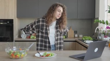 Bright Home Kitchen 'da konuşurken kıvırcık kadın hareketi. Etkileyici Konuşma Anı, Konforlu İçişleri, Doğal Işık, Gündelik Atmosfer, Günlük Dijital İletişim