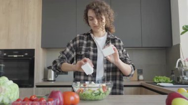 Parlak mutfak sahnesinde tuzlu ve biberli taze salata. Yemek pişirme, sağlıklı yaşam tarzı, ev yapımı yemek, taze malzemeler, organik gıdalar, modern içişleri, mutfak hazırlıkları için mükemmel.