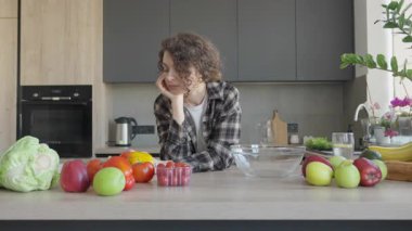 Mutfaktaki taze sebzelere bakarken bir kadın yemek için kafa yoruyor. Yaratıcı Yemek Anı, Sağlıklı Yemek İlhamları, Doğal Işık, Sıcak Ev Titreşimleri, Günlük rutin, Organik İçindekiler