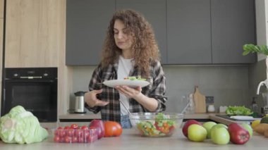 Samimi mutfak ortamında taze salata pişirirken telefonda yemek tarifi taranıyor. Mutfak ilhamı için mükemmel bir an. Sağlıklı Yaşam Tarzı Parlak, Modern Ev Ortamında Yakalandı