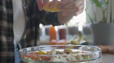 Parlak Sağlıklı Ev Mutfağı Sahnesinde Limon Suyu Çiseleyen Salata Kasesi. Yüksek kalite 4k görüntü