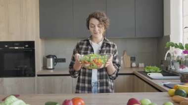 Gülümseyen Kadın Parlak Mutfak Sahnesinde Taze Salata Kokan Aroma. Doğal Sağlıklı Yaşam Anı Sunlit Ev İçi Organik Malzemelerle Ev Yapımı Pişirmenin Basit Mutluluğunu Yakalıyor