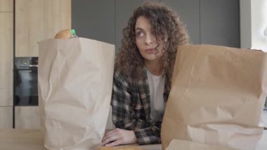 Alışveriş gezisinden sonra, evde alışveriş poşetlerini açan yorgun bir kadın. Tükenmiş Kadın Piyasadan Dönüşü, Sıcak Modern İçlerinde Taze Ürün Sıralaması, Günlük Yaşamı Yakalama