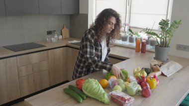 Parlak Minimalist Mutfaktaki Market Taşımacılığından Sonra Yeni Ürün Organize Etmek. Modern Ev İçi 'nde Renkli Sebzeleri Açan Kadın Sağlıklı Yaşam Konsepti