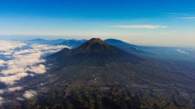 Prau Dağı 'nın zirvesinden, üç yüksek zirvenin nefes kesici manzarası gözler önüne seriliyor. Yürüyüşçülerin favorilerinden biri olan bu çarpıcı manzara Endonezya 'nın doğal güzelliğini ve macerasını gözler önüne seriyor..