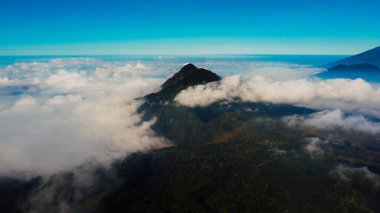 Yukarıdan çekilen İjen Krateri 'nin ruhani güzelliğini deneyimleyin. Hassas bir sis tabakasının manzarayı kapladığı yerden. Kraterlerin açık mavi renkleri büyülü bir kontrastlık yaratır ve Mavi Ateş