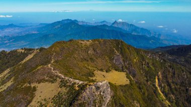 Güneşin manzaranın üzerine altın bir parıltı saçtığı Arjuno Dağı 'nın tepesinde nefes kesen günbatımını hissedin. Gökyüzü çarpıcı bir mavi ve canlı renk karışımına dönüşür.