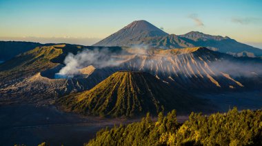 Bromo Dağı 'nda çarpıcı bir gündoğumu canlı bir günbatımını gözler önüne seriyor. Bulutlar zirveyi zarifçe kaplıyor ve Doğu Java' nın doğal güzelliğini gözler önüne seriyor..