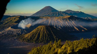 Bromo Dağı 'nda çarpıcı bir gündoğumu canlı bir günbatımını gözler önüne seriyor. Bulutlar zirveyi zarifçe kaplıyor ve Doğu Java' nın doğal güzelliğini gözler önüne seriyor..