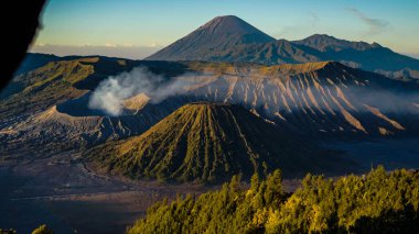 Bromo Dağı 'nda çarpıcı bir gündoğumu canlı bir günbatımını gözler önüne seriyor. Bulutlar zirveyi zarifçe kaplıyor ve Doğu Java' nın doğal güzelliğini gözler önüne seriyor..
