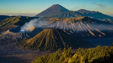 Bromo Dağı 'nda çarpıcı bir gündoğumu canlı bir günbatımını gözler önüne seriyor. Bulutlar zirveyi zarifçe kaplıyor ve Doğu Java' nın doğal güzelliğini gözler önüne seriyor..