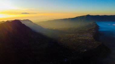 Bromo Dağı 'nda çarpıcı bir gündoğumu canlı bir günbatımını gözler önüne seriyor. Bulutlar zirveyi zarifçe kaplıyor ve Doğu Java' nın doğal güzelliğini gözler önüne seriyor..