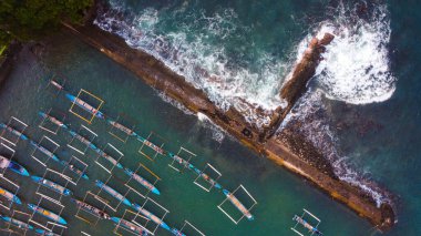 Yukarıdan yakalanan canlı balıkçı limanı Lampung 'u keşfedin. Renkli tekneler, berrak mavi suların arkaplanına karşı güzelce düzenlenmiştir. Limanı kaplayan büyüleyici evleri vardır.