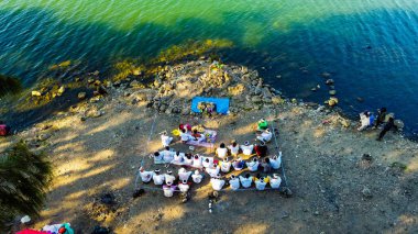 Rinjani 'nin zirvesinden bir hava videosu aşağıdaki muhteşem Segara Anak Gölü' nü gösteriyor. Canlı mavi gökyüzü ve bulutlarla çevrili gölün dingin güzelliği dramatik manzaraya karşı duruyor..
