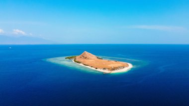 Discover breathtaking aerial views of Kenawa Island in the blue sea, featuring a small hill and vast savanna in the uninhabited area of Sumbawa, Nusa Tenggara Barat. clipart