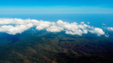 Tambora Dağı 'nın zirvesinin havadan görünüşü mavi gökyüzünün altında nefes kesen bir manzarayı gözler önüne seriyor, güneş doğarken, göz kamaştırıcı arazi üzerinde altın renkler seriyor..