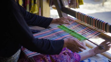 Batı Nusa Tenggara ya da Lombok 'tan geleneksel bir Endonezya el dokuması olan Kain Tenun' un rengi Sade köyünde hediyelik eşya olarak asılı duruyor.: