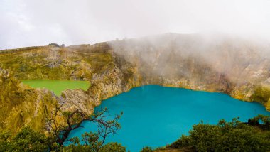 Ende 'deki Kelimutu' nun Üç Renkli Gölü 'nün büyüleyici hava görüntüsünü deneyin. Mistik bulutlara sarılmış, efsanevi zengin bu büyülü yer, ruhu büyüleyen nefes kesici bir manzara sunuyor..