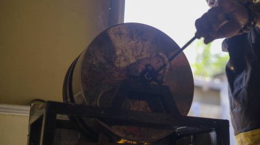 Bajawa 'nın geleneksel kahve pişirme süreci, zengin fasulyelerin ustalıkla kızartılması, yerel kültür ve lezzetin özünü yakalaması..