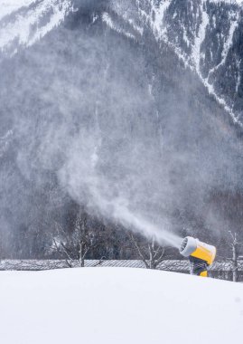 Snow canons making fake snow  in Planards skislope in the beginning of the season. Chamonix, France. Vertical. clipart