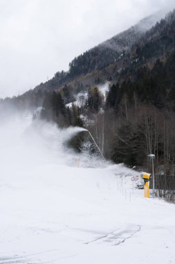 Snow canons making fake snow  in Planards skislope in the beginning of the season. Chamonix, France. Vertical. clipart