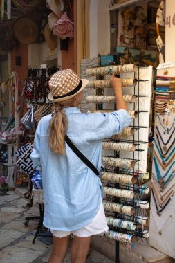 Genç bir turist kadın, Corfus 'un eski kasabası Kerkyra, Yunanistan' ın büyüleyici sokaklarını keşfederek, tarihi mimarinin ve canlı atmosferinin tadını çıkarıyor..