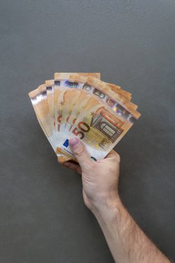Euro Banknotları Sayan Adam. Avro banknotlarını tutan ve sayan bir adam, yakın plan el ve para.